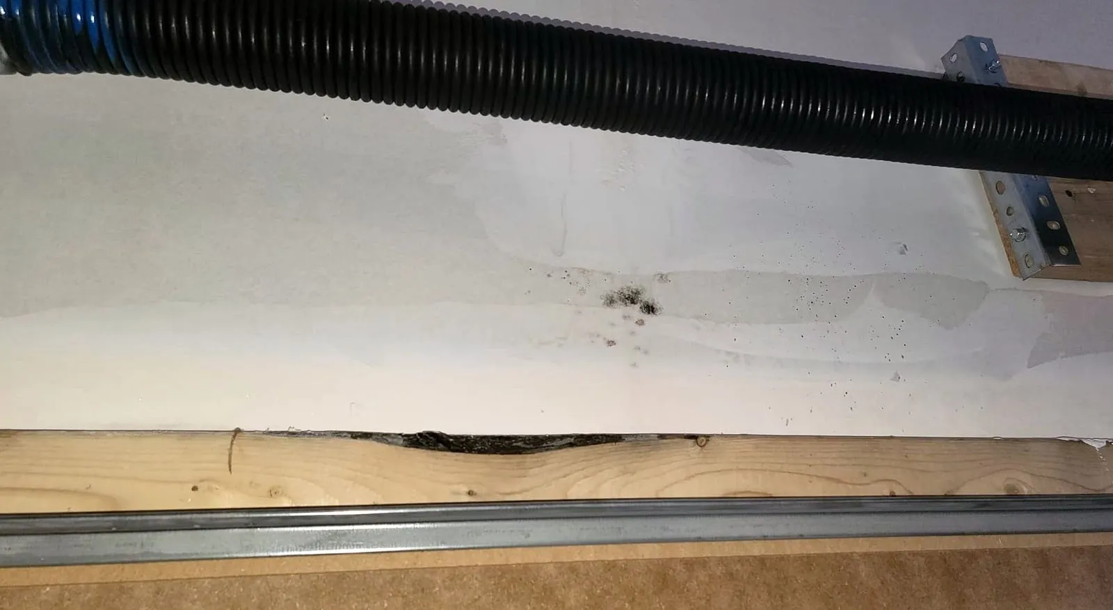 Extraction hose and containment along a wall during a Loftin Restoration water removal job